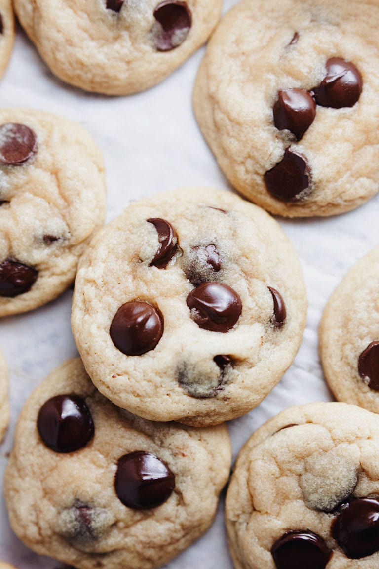 Chewy chocolate chip cookies laid out on parchment paper.