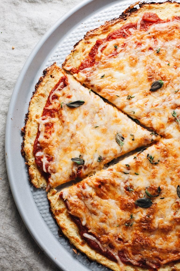 a picture of cauliflower pizza with slice cut out of it