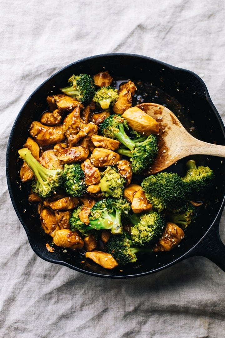 Black cast iron pan on a grey napkin with chicken teriyaki and