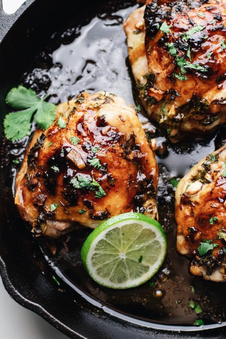 A close up of cilantro chicken in a cast iron pan.