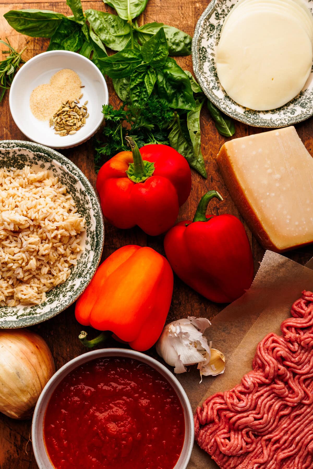 Ingredients for stuffed peppers arranged on a wooden background.