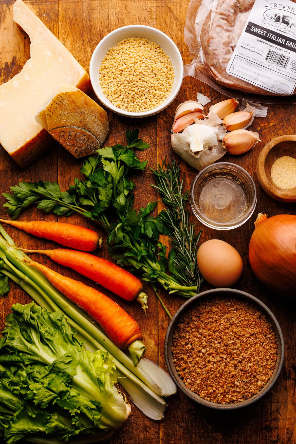 Ingredients for Italian wedding soup arranged on a wooden board.