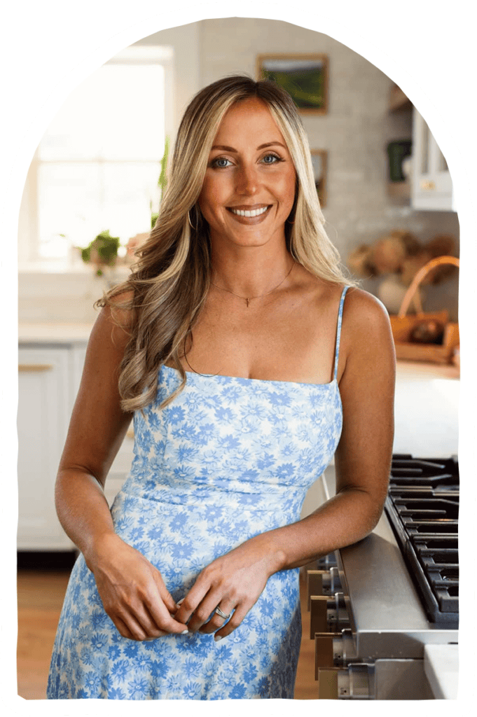 Bethany Kramer in her kitchen leaning against the counter in a light blue dress