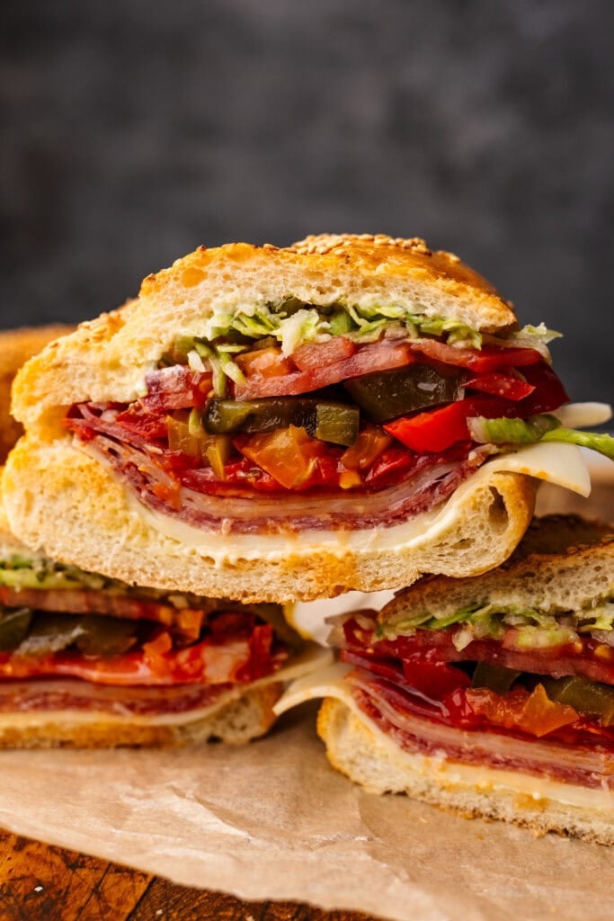 Slices of Italian sub stacked with a dark gray background.