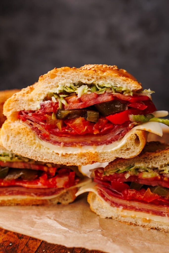Slices of Italian sub stacked with a dark gray background.