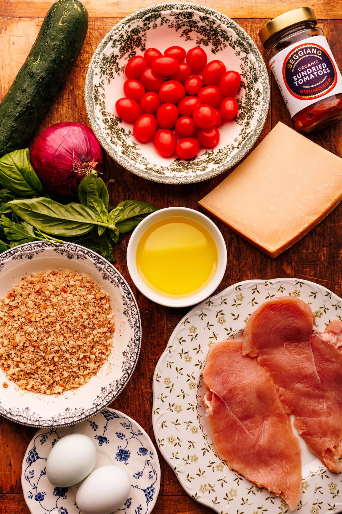 Ingredients for chicken cutlets and salad arranged on a wooden board.