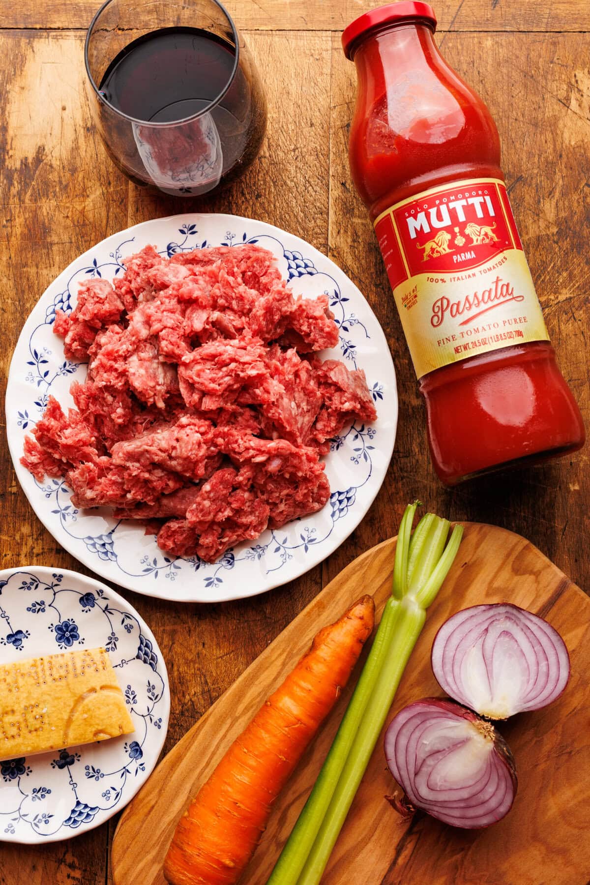 Ingredients for Italian ragu displayed on a wooden board.